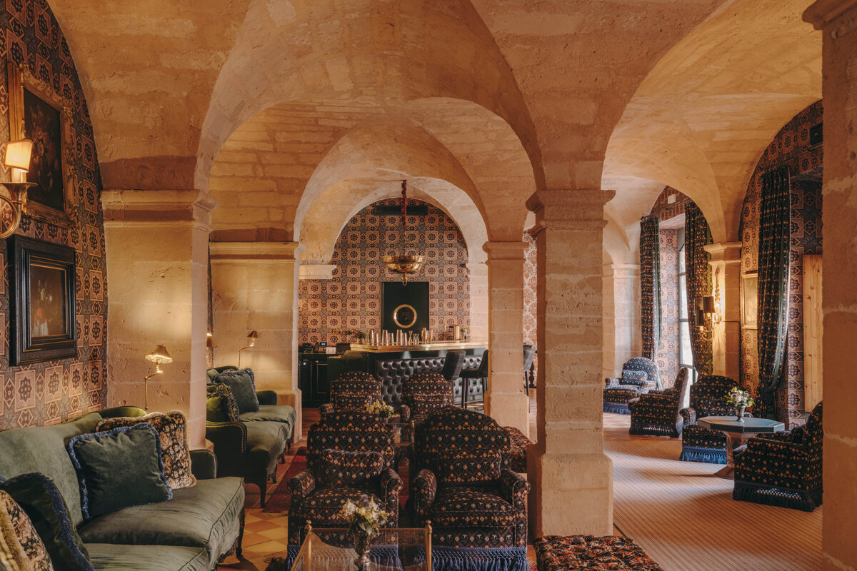 A room with arches and a couch and chairs