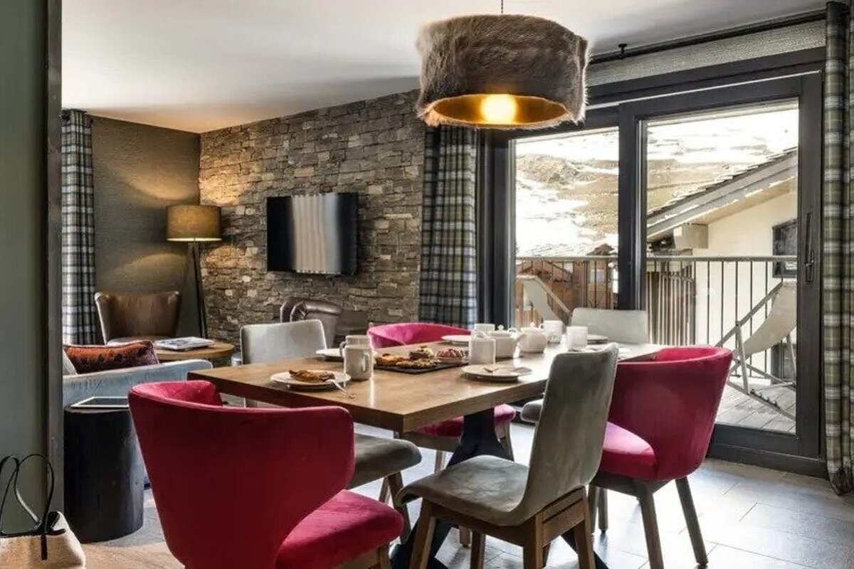 A dining room with a table and chairs and a balcony