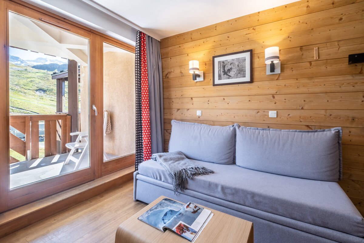 A living room with a couch and a magazine on a table