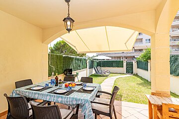 A patio with a table and chairs under an awning