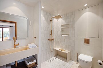 A bathroom with a walk in shower and a sink