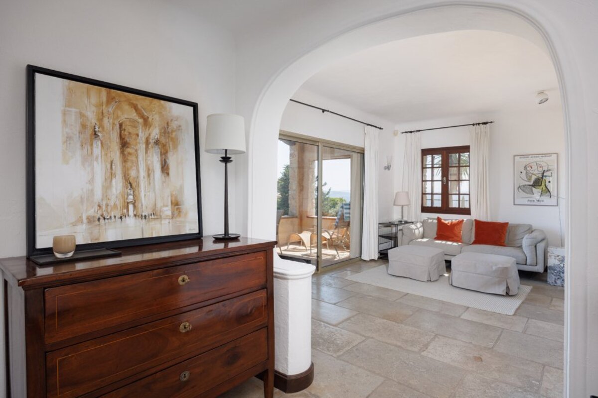 A living room with a dresser and a painting on the wall