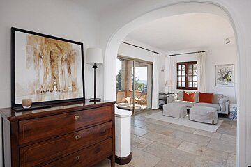 A living room with a dresser and a painting on the wall