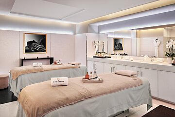 A couple of massage tables in a room with a picture on the wall