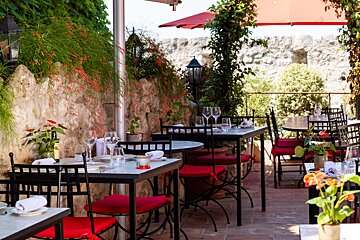 A restaurant with tables and chairs and a red umbrella