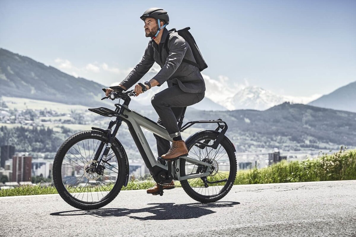 A man wearing a helmet is riding an electric bike