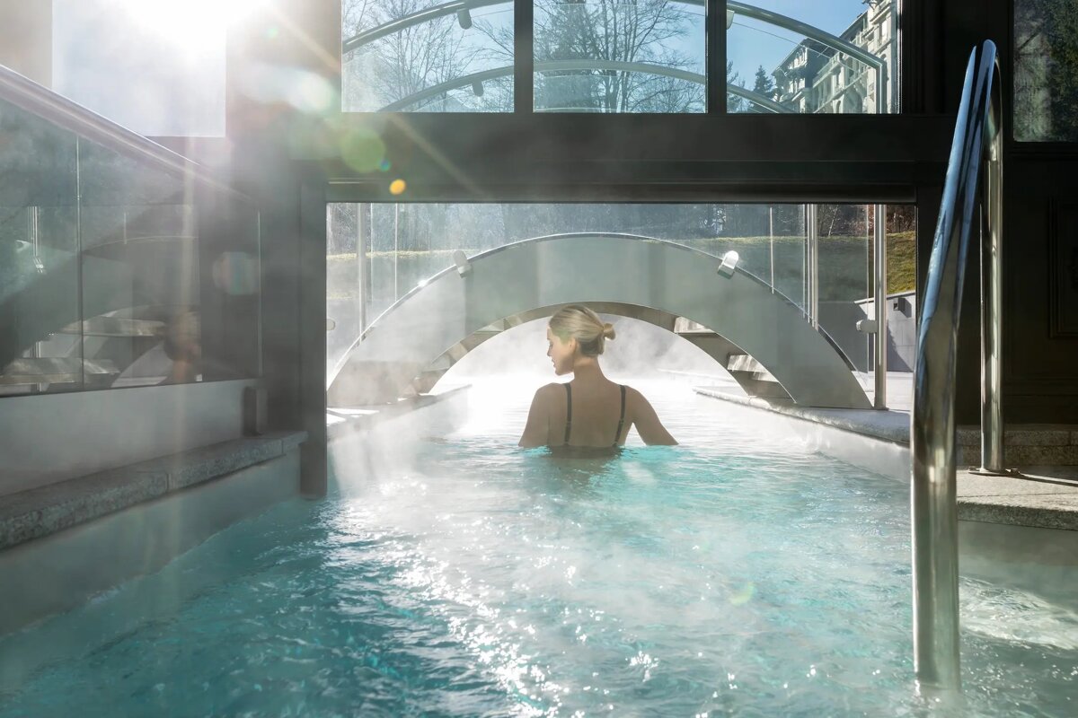 A woman is swimming in a pool under a bridge