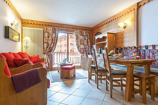 A living room with a wooden table and chairs