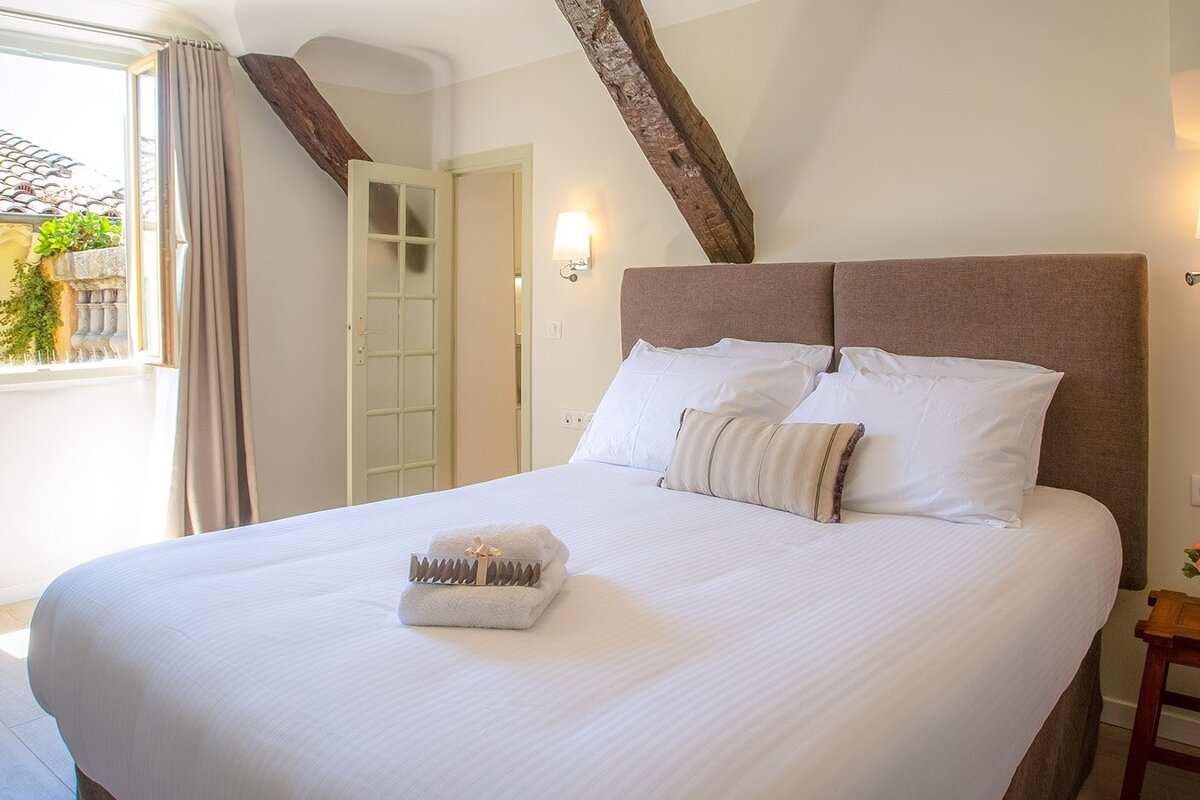 A bedroom with a large bed and a window