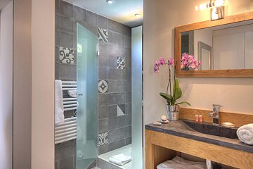 A bathroom with a sink and a glass shower door