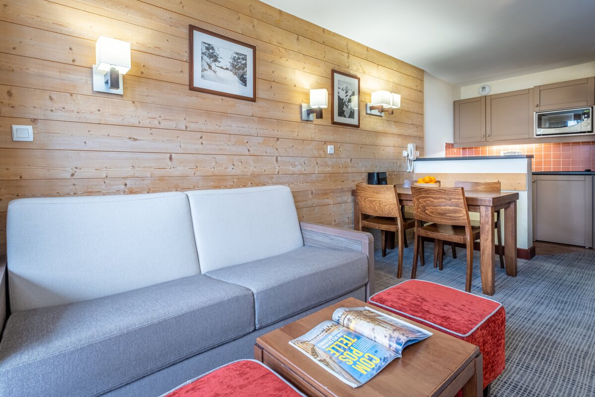 A living room with a couch and a table with a magazine on it that says keep calm