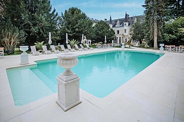 A large swimming pool with chairs and umbrellas around it