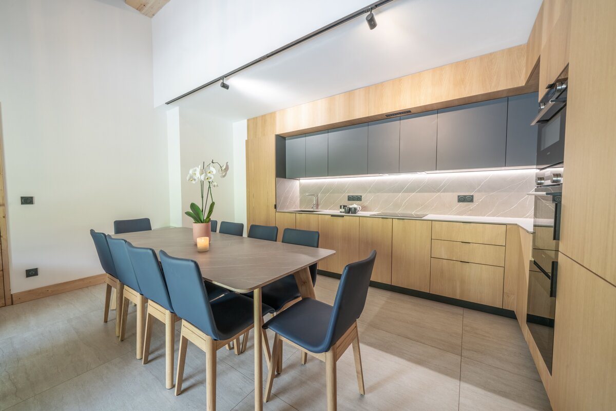 A kitchen with a table and chairs and a vase of flowers