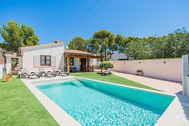 A house with a large swimming pool in front of it