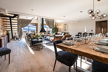 A living room with a dining table and chairs and a fireplace