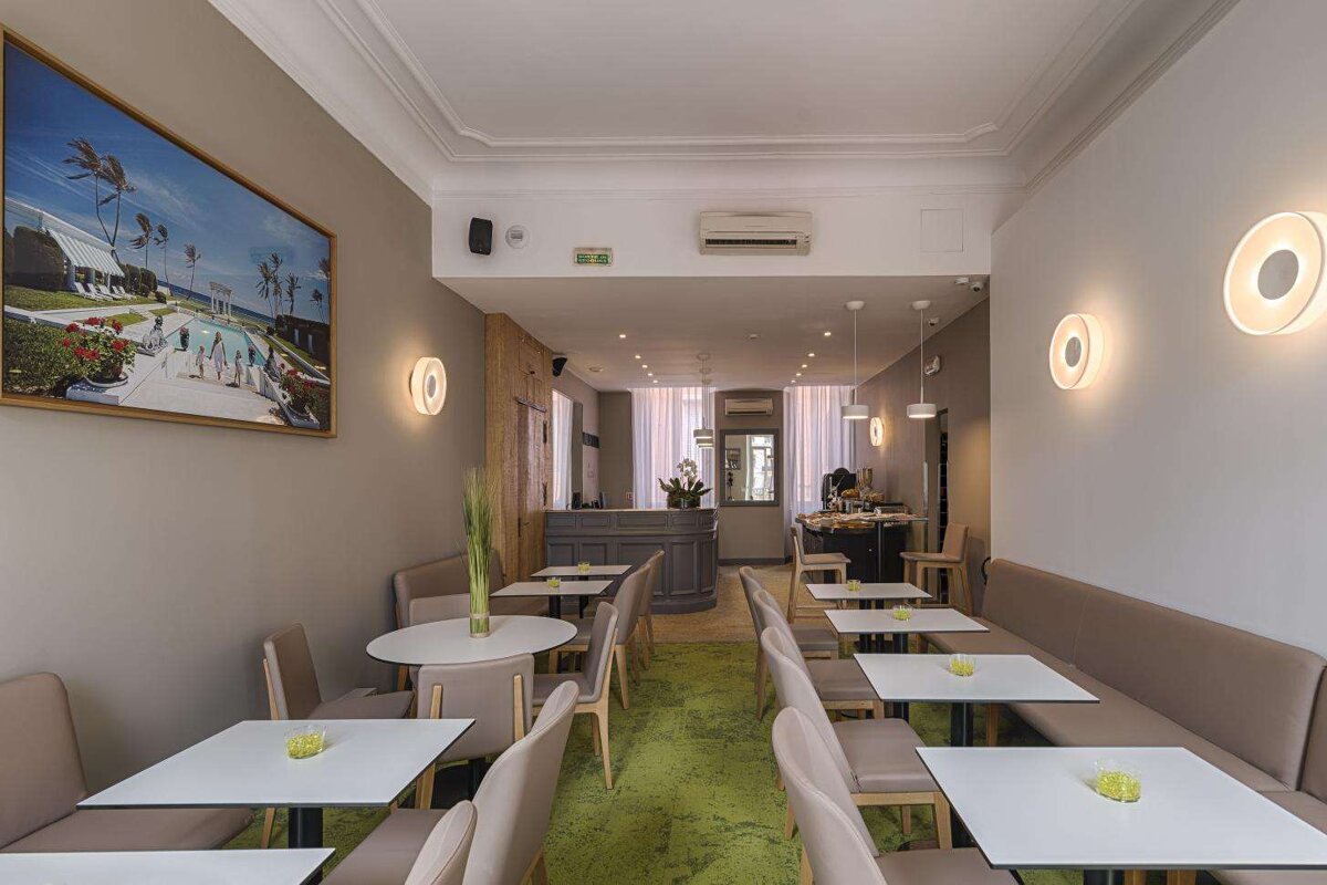 A restaurant with tables and chairs and a painting on the wall