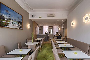 A restaurant with tables and chairs and a painting on the wall