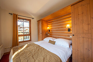 A bedroom with a bed and a wooden wall