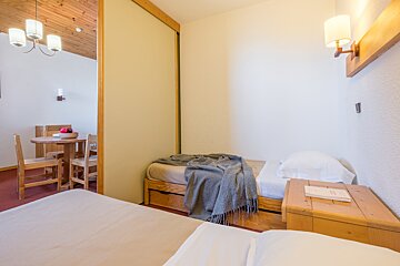 A bedroom with two beds and a table and chairs