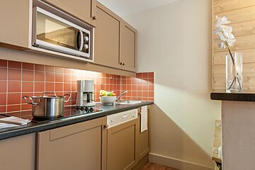 A kitchen with a pot on the stove and a coffee maker