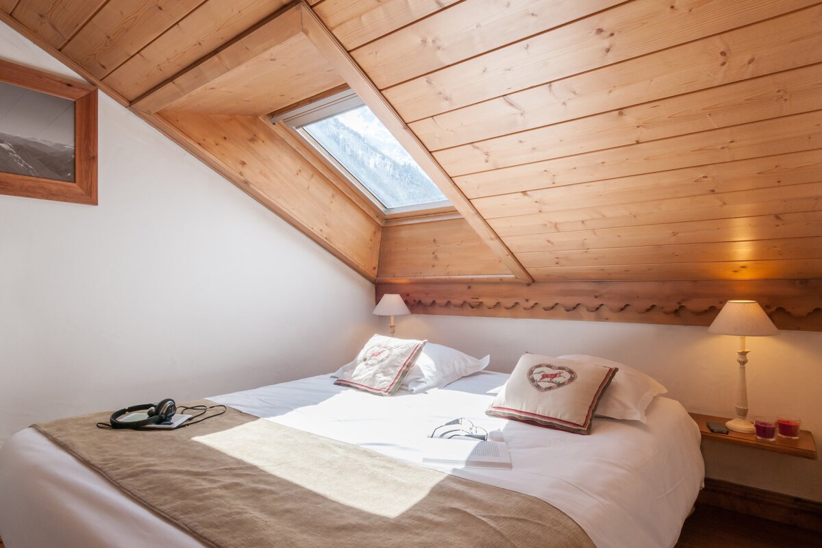 A bedroom with a bed and two pillows with hearts on them