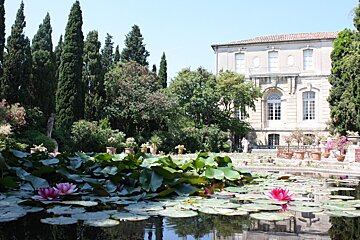 A large building is behind a pond filled with water lilies