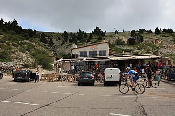 a cyclist passing a restaurant on the way up mont ventoux