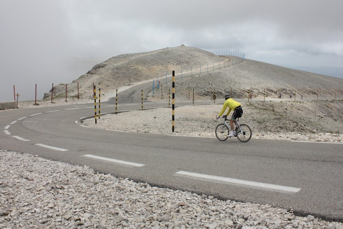 a cyclist free-wheeling down mont ventoux in provence