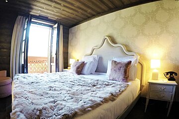 A bedroom with a bed and a nightstand with a phone on it