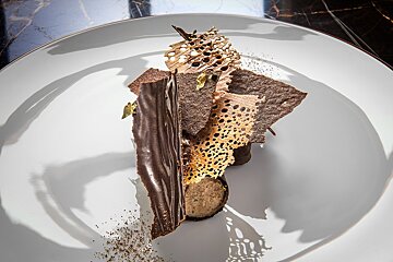 A white plate with a piece of chocolate on it