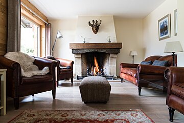 A living room with a fireplace and two chairs