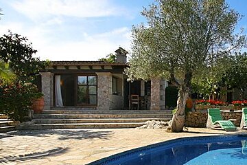 There is a large swimming pool in front of a house