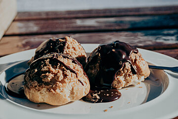 A white plate topped with ice cream and chocolate sauce