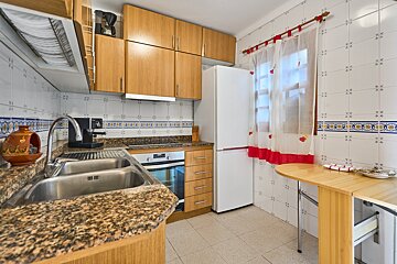 A kitchen with a sink and a fridge and a table