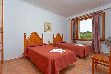 A bedroom with two twin beds and a fan