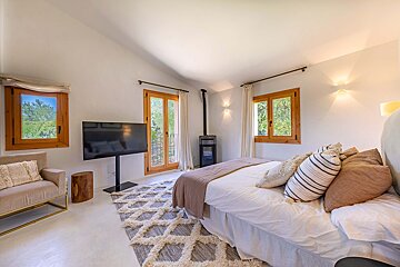 A bedroom with a large bed and a flat screen tv