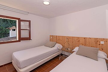 A bedroom with two twin beds and a window