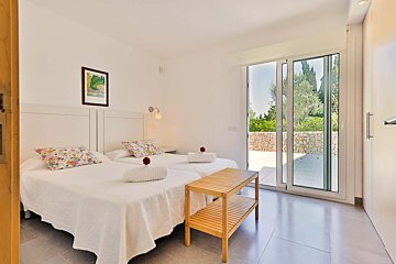 A bedroom with two beds and a sliding glass door