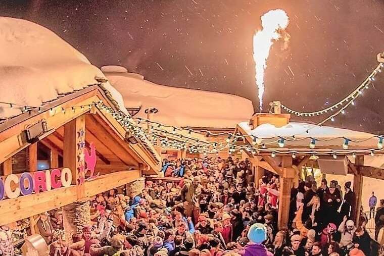 A crowd of people are gathered in front of a building that says cocorico