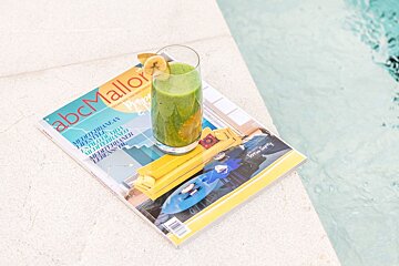 A green smoothie with a banana slice rests on an 