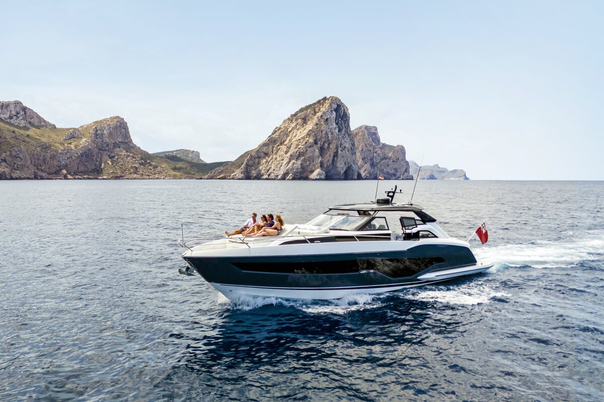 A group of people sit on the back of a boat in the ocean