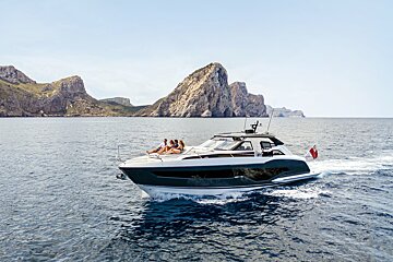 A group of people sit on the back of a boat in the ocean