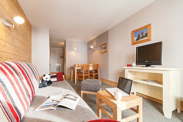 A living room with a couch and a laptop on a table
