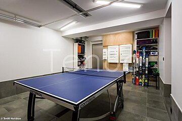 A blue ping pong table in a room with a sign that says ten80 holidays