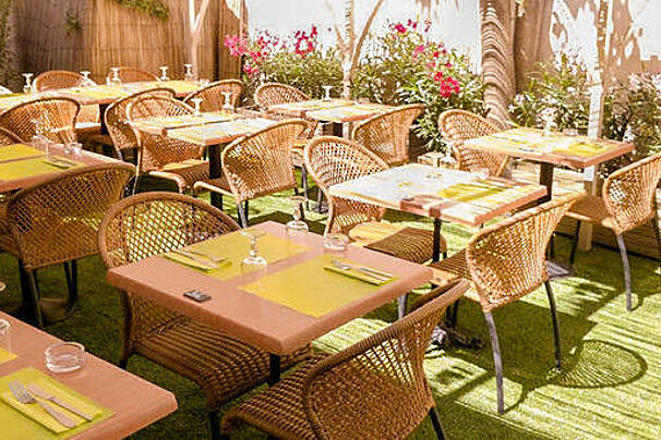A restaurant with tables and chairs set up on a lush green lawn