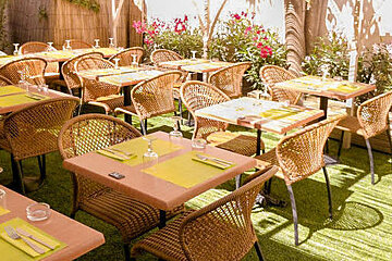 A restaurant with tables and chairs set up on a lush green lawn