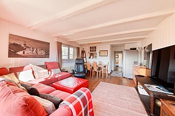 A living room with a red couch and a black chair
