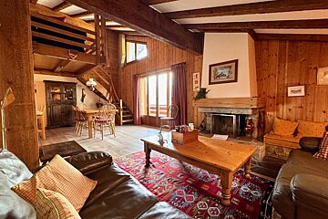 A living room with a couch a table and a fireplace