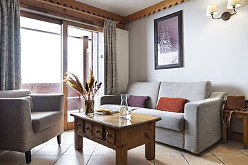 A living room with a couch and two chairs