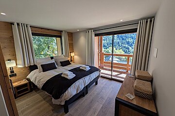 A bedroom with a large bed and a large window